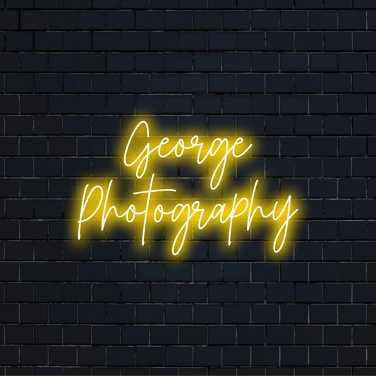 George Photography Personalized Neon Light with glowing lettering against black brick wall