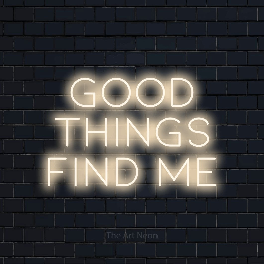 "Good Things Find Me" script-style LED neon sign on a black brick wall