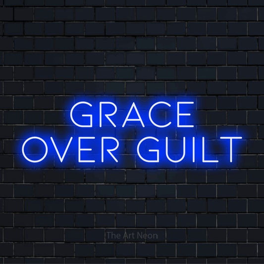 "Grace Over Guilt" neon text design on a black brick wall