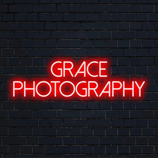 Grace Photography Custom Name Neon Sign, glowing neon text against brick backdrop
