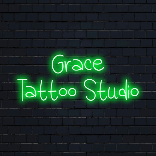 Grace Tattoo Studio Custom Name Neon Sign, glowing neon text on dark brick background