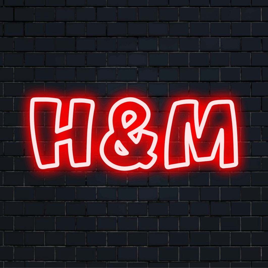 H M LED Neon Sign, bright LED glow on dark brick background