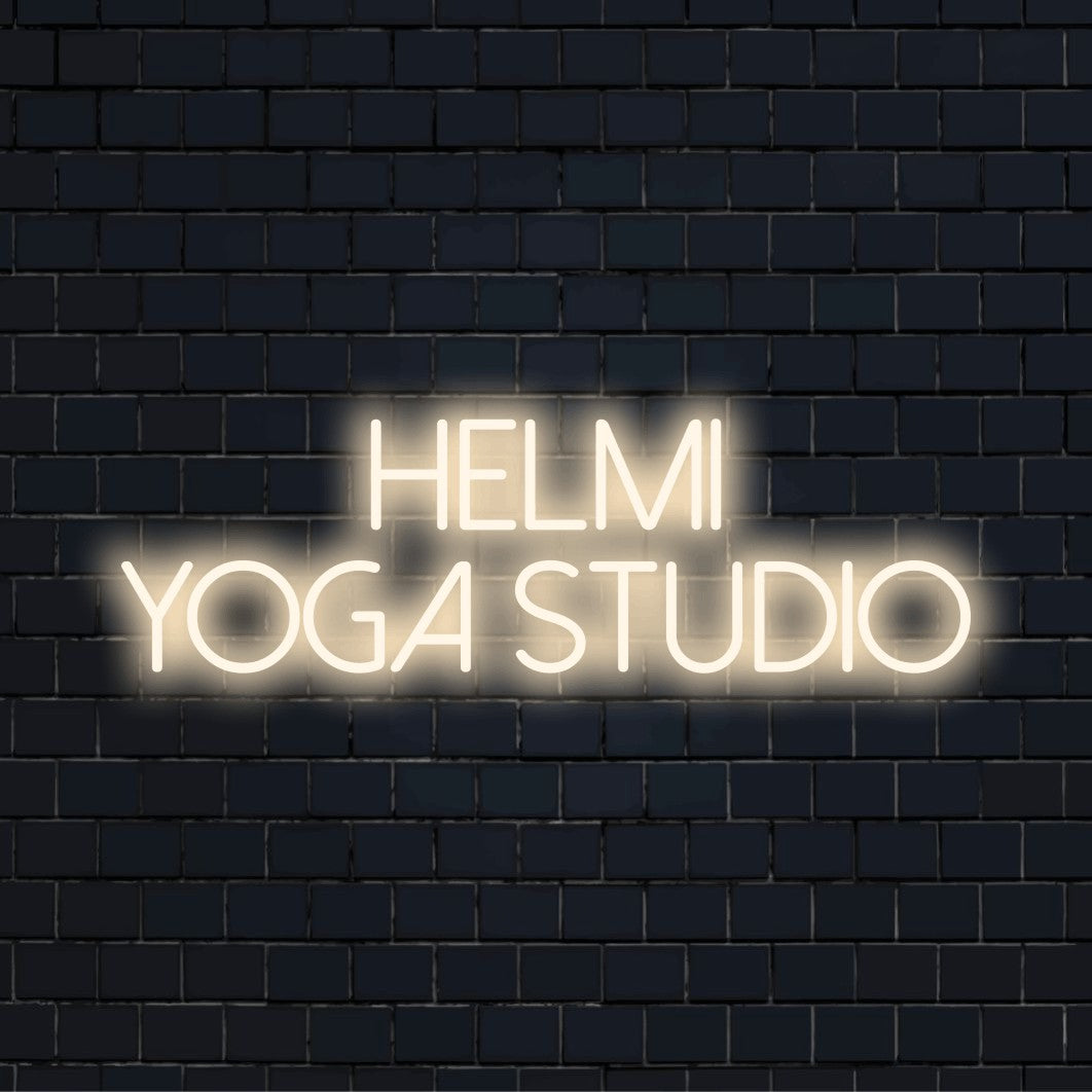 Helmi Yoga Studio Personalized Neon Light with glowing lettering against brick backdrop