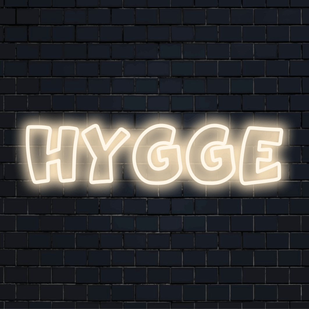 Hygge Neon Sign, glowing neon text against brick backdrop
