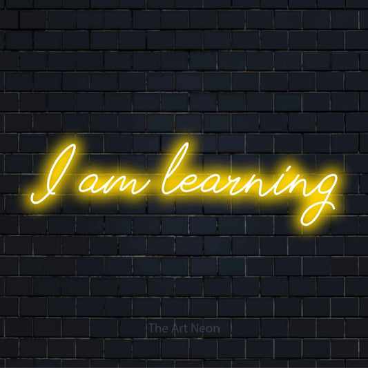 "I Am Learning" neon text design on a black brick wall