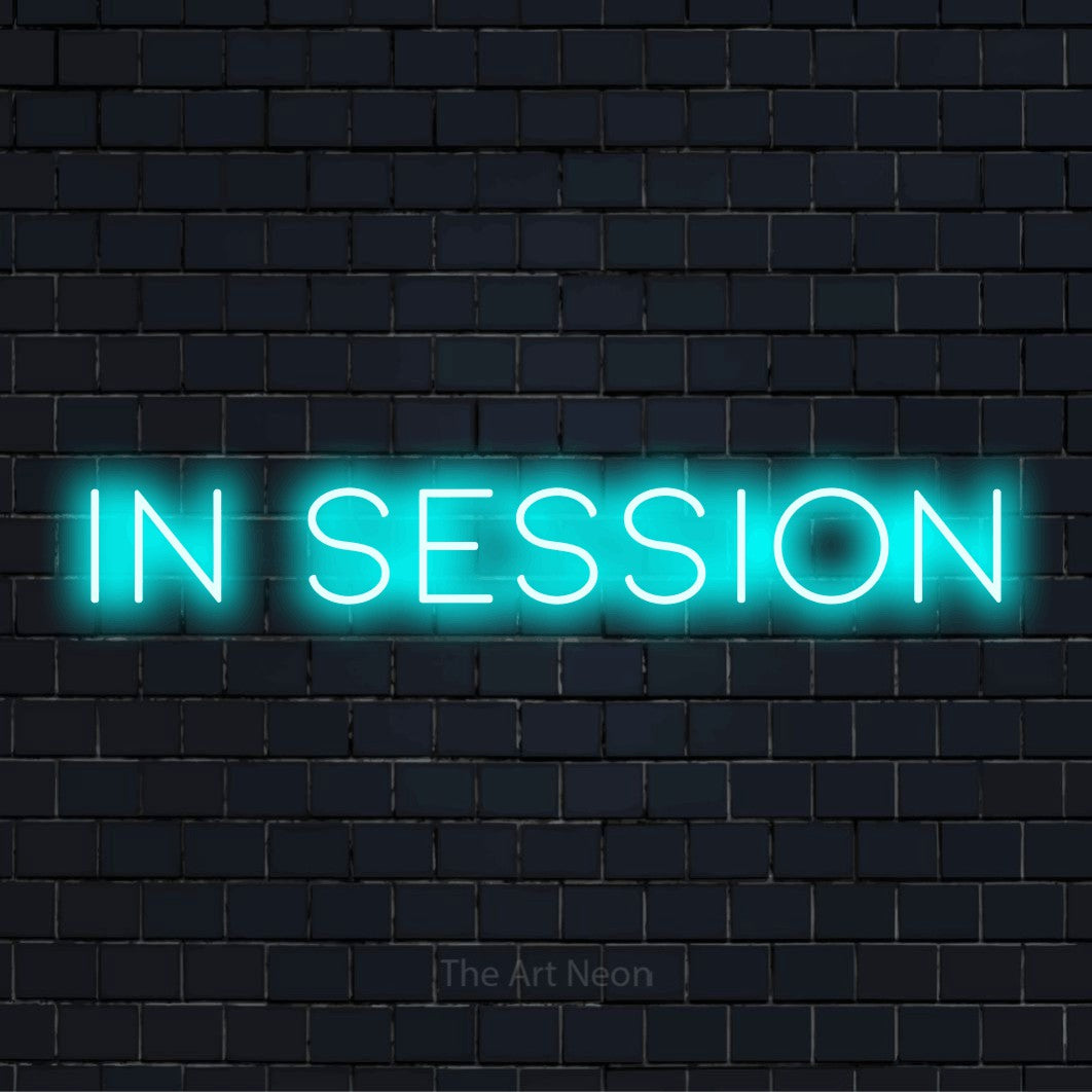 "In Session" glowing LED neon sign on a black brick wall
