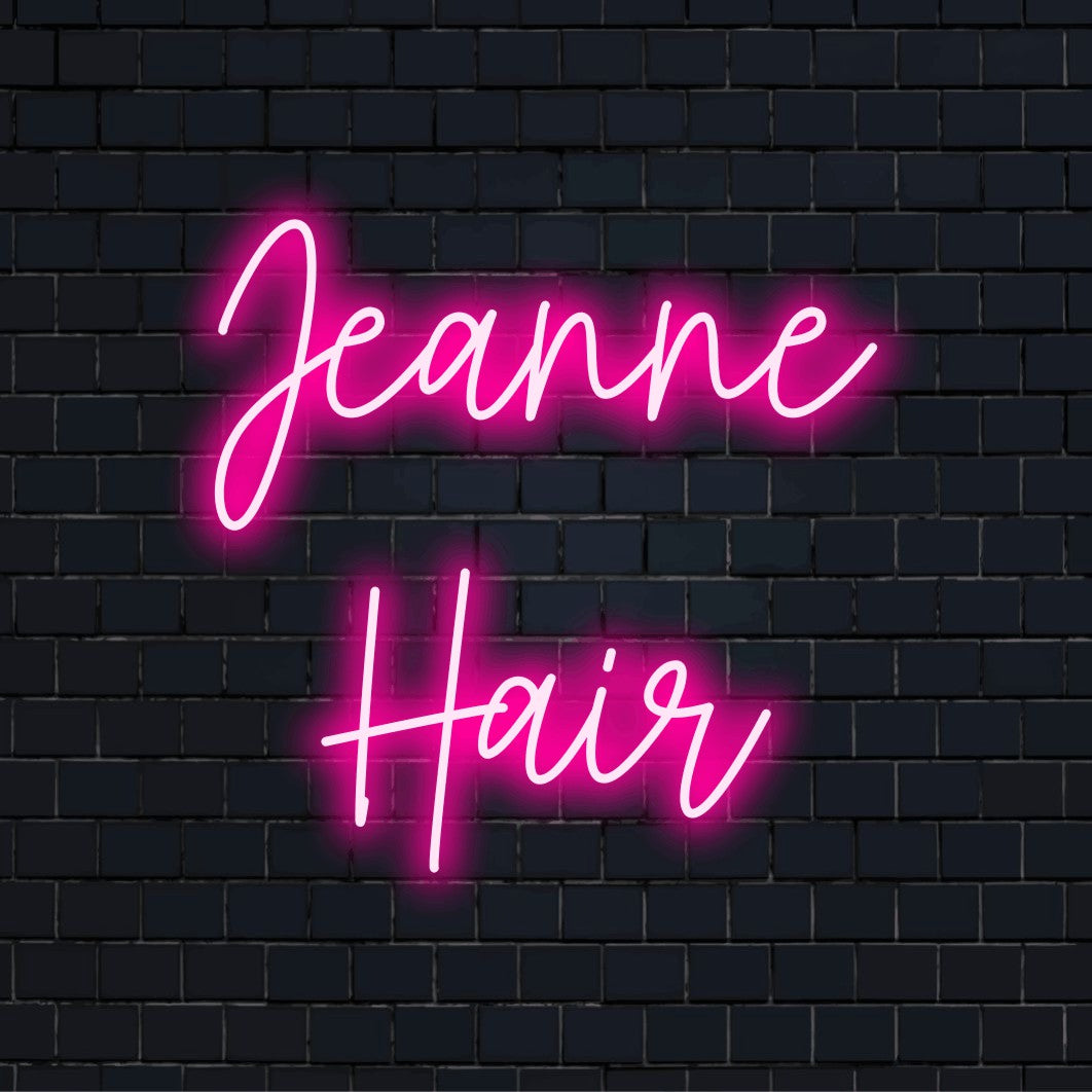 Jeanne Hair Personalized Neon Light with neon text light against brick backdrop