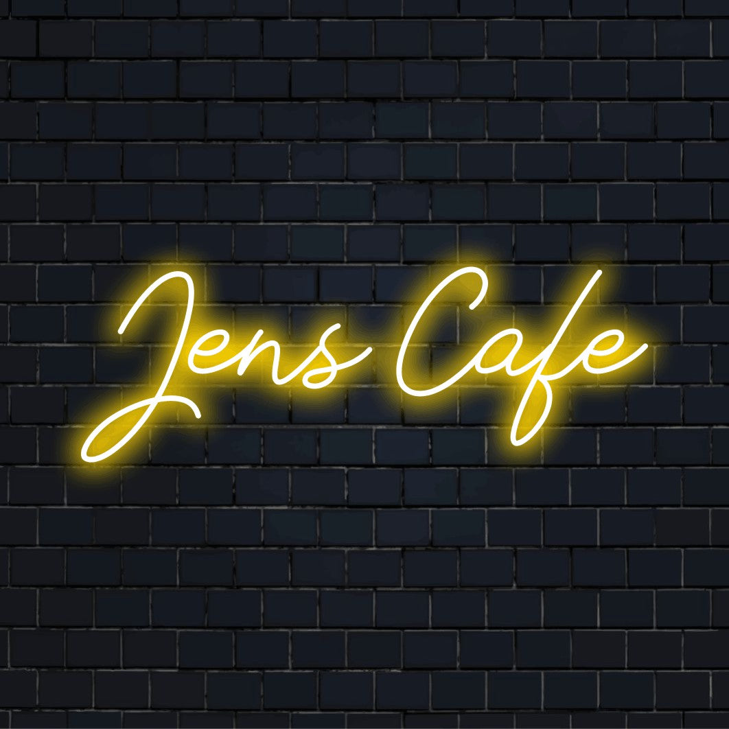 Jens Cafe Personalized Neon Light with glowing neon text against black brick wall