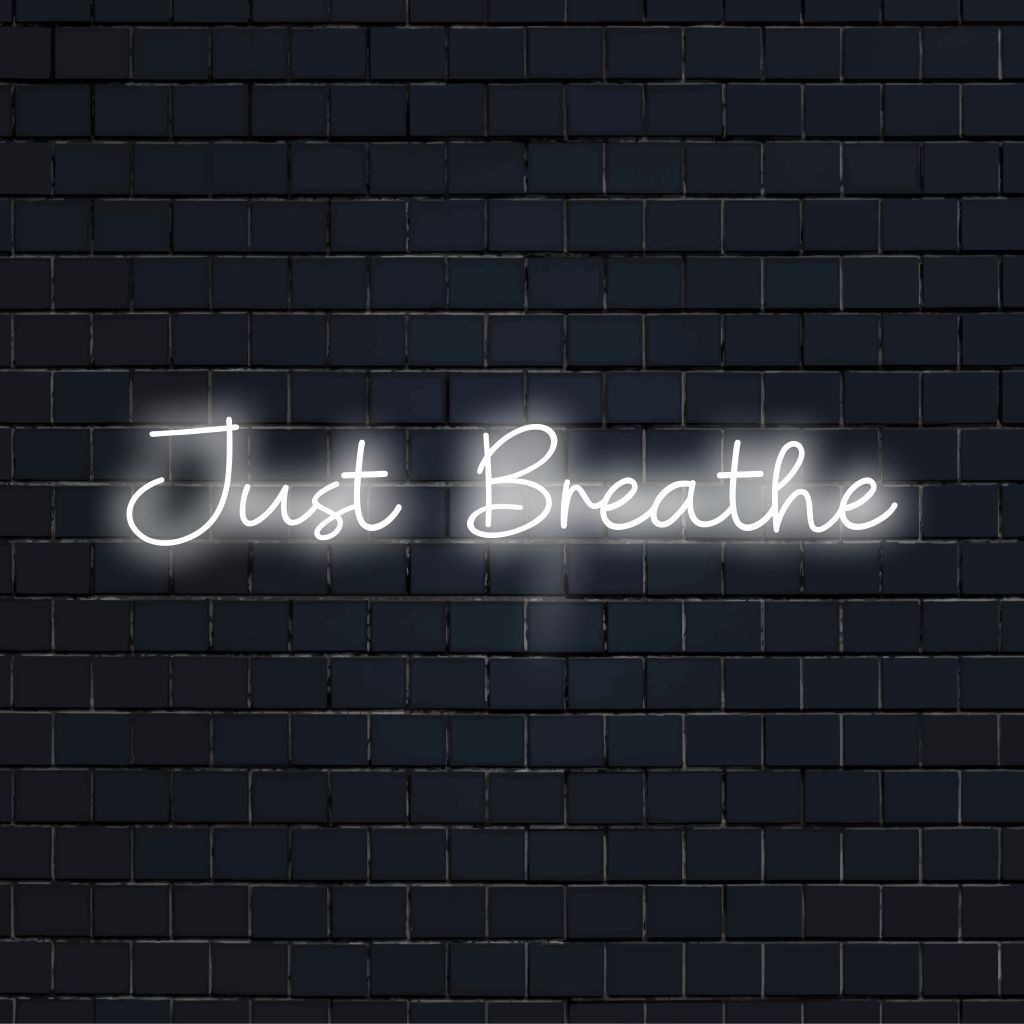 Just Breathe Neon Sign, glowing lettering against brick backdrop