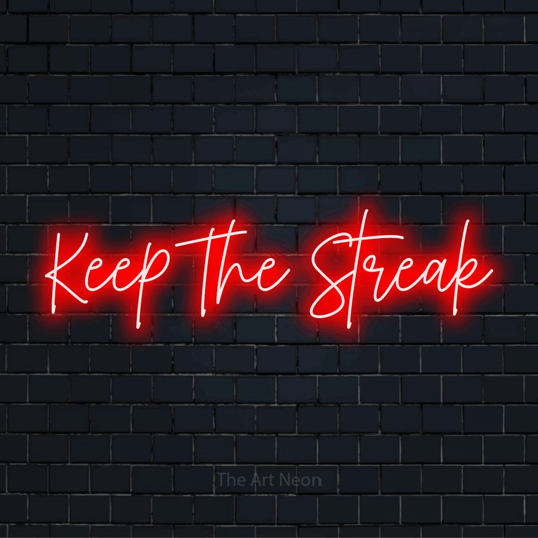 "Keep The Streak" glowing LED neon sign on a black brick wall