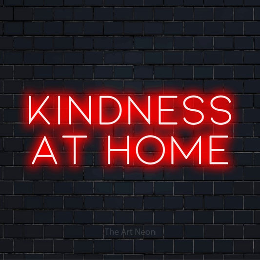"Kindness At Home" script-style LED neon sign on a black brick wall