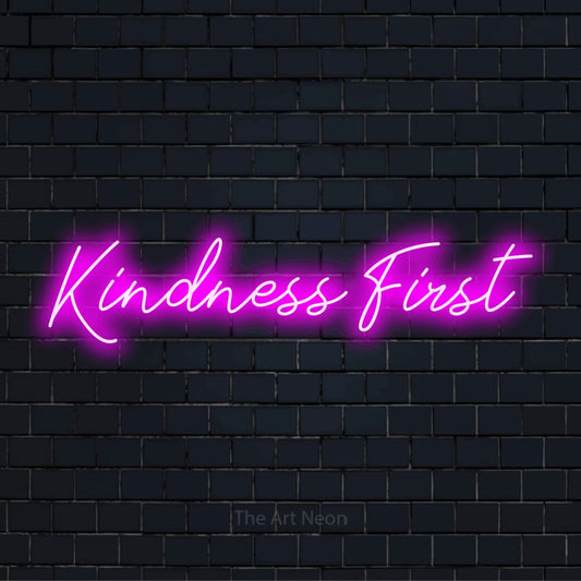 "Kindness First" neon text design on a black brick wall