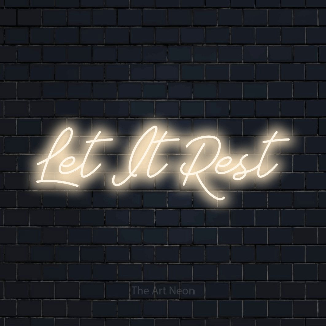 "Let It Rest" neon text design on a black brick wall