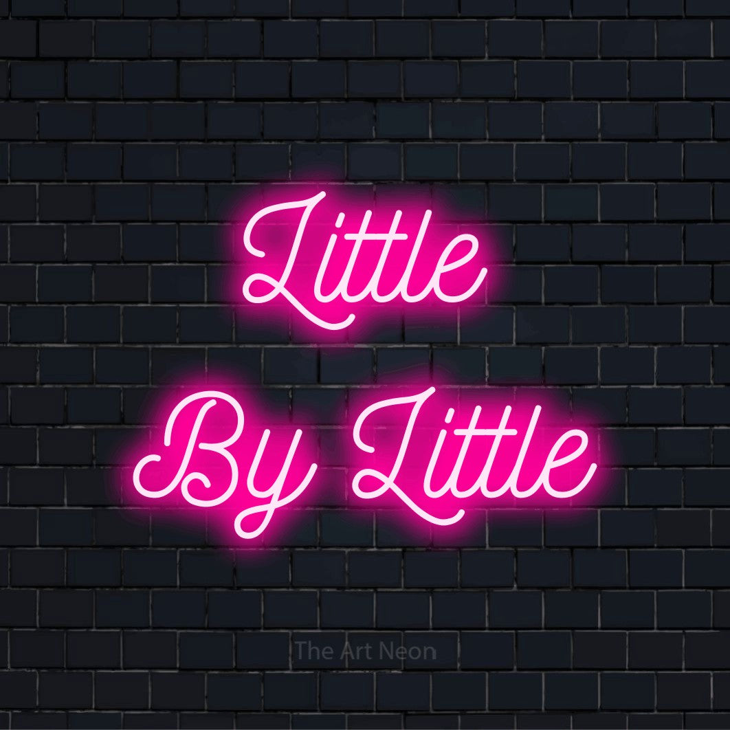 "Little By Little" glowing LED neon sign on a black brick wall