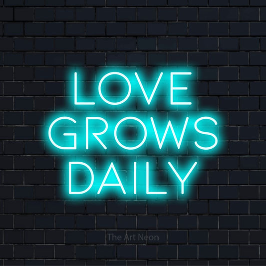 "Love Grows Daily" LED neon sign on a black brick wall