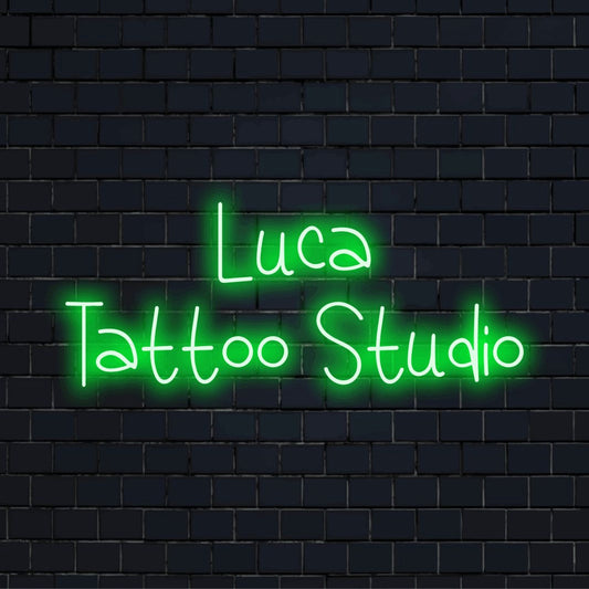 Luca Tattoo Studio Custom Name Neon Sign, bright LED glow on black brick background