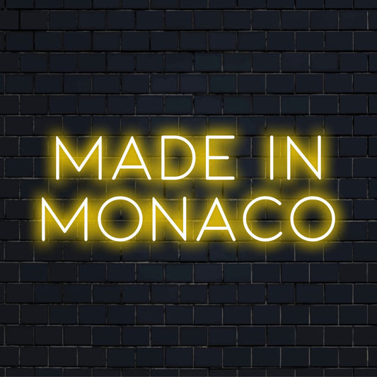 Made In Monaco Neon Light with glowing lettering on black brick background