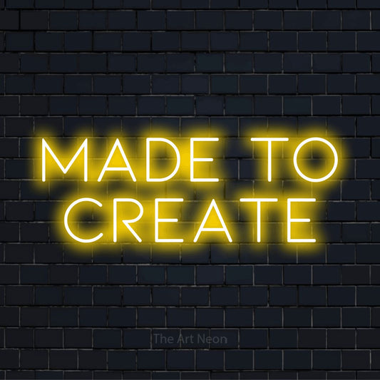 "Made To Create" neon text design on a black brick wall