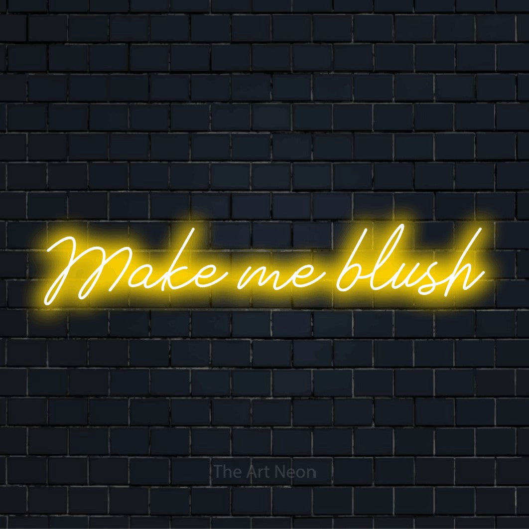 "Make Me Blush" LED neon sign on a black brick wall