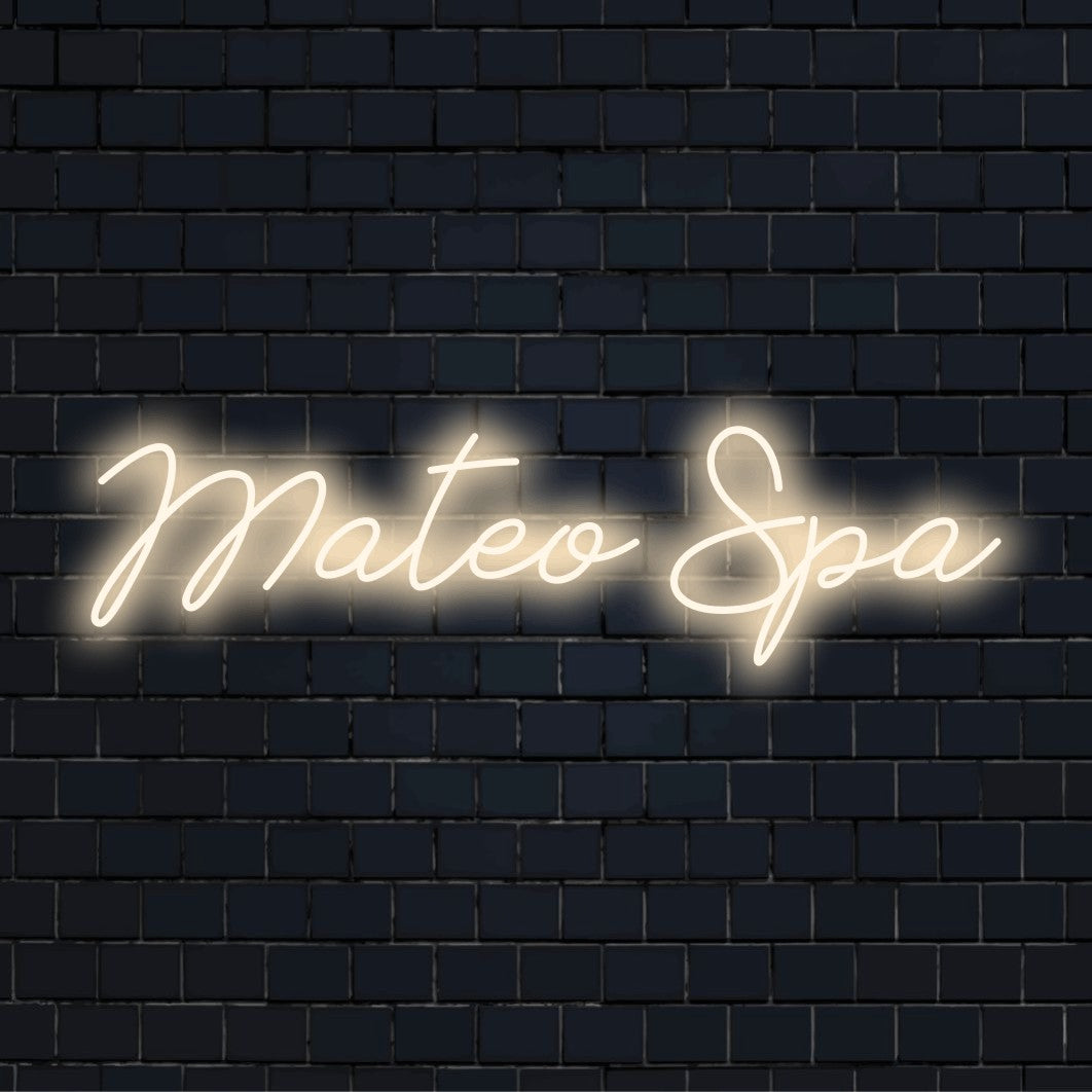 Mateo Spa Personalized Neon Light with bright neon lettering on dark brick wall
