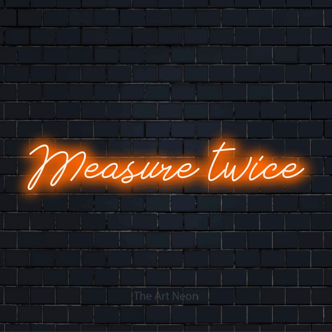 "Measure Twice" text design with neon effect on a black brick wall