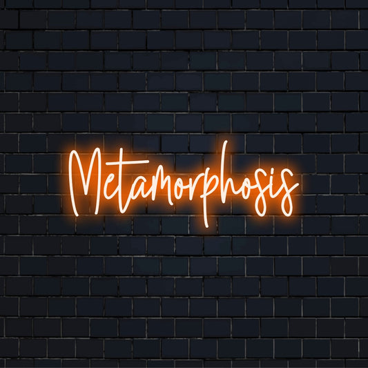Metamorphosis Neon Sign, glowing lettering against brick backdrop