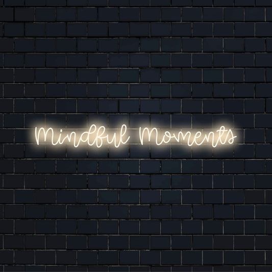 Mindful Moments LED Neon Sign, glowing wall decor against black brick wall
