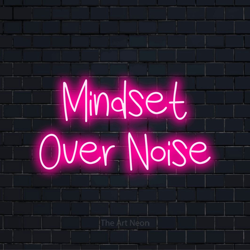 "Mindset Over Noise" script-style LED neon sign on a black brick wall