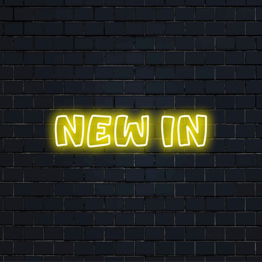 New In Neon Sign, bright LED glow against black brick wall