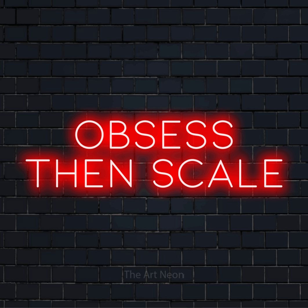 "Obsess Then Scale" neon text design on a black brick wall