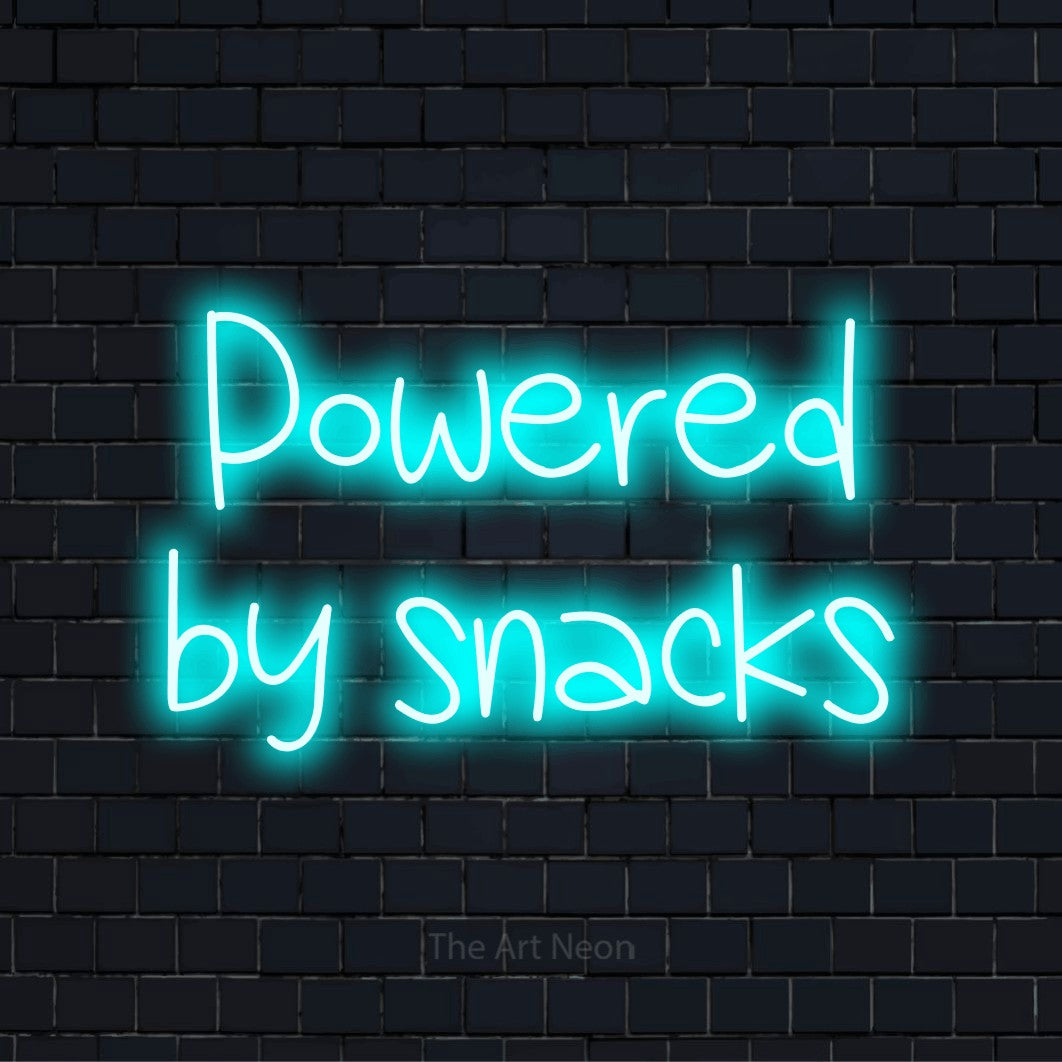 "Powered By Snacks" text design with neon effect on a black brick wall