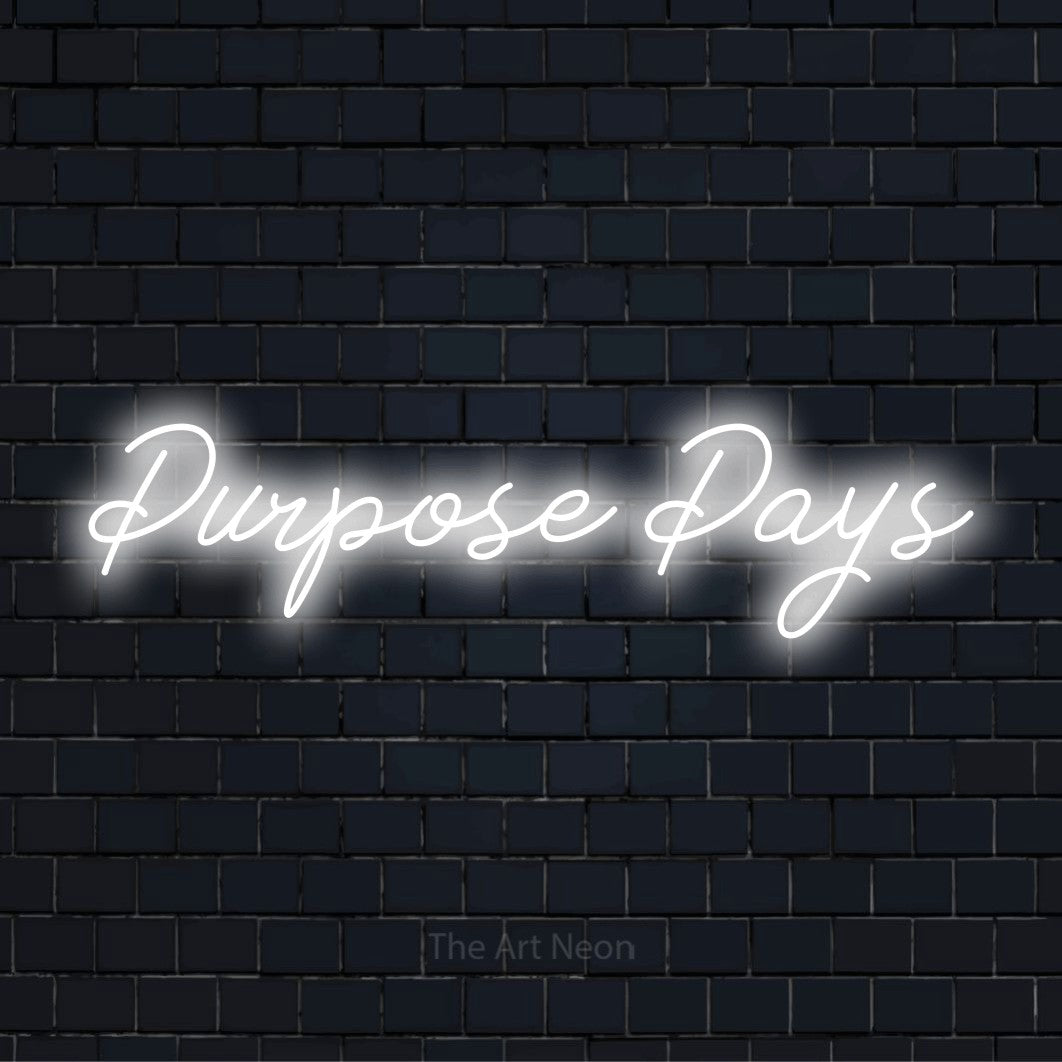 "Purpose Pays" script-style LED neon sign on a black brick wall