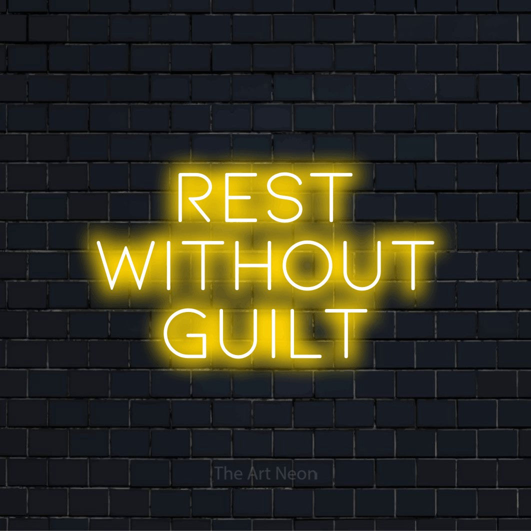 "Rest Without Guilt" glowing LED neon sign on a black brick wall