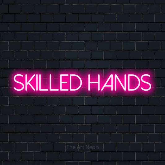 "Skilled Hands" text design with neon effect on a black brick wall