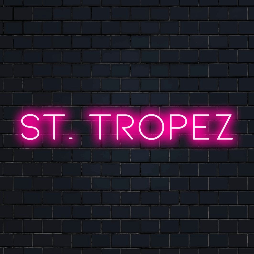 St Tropez Neon Light with bright neon glow on black brick background
