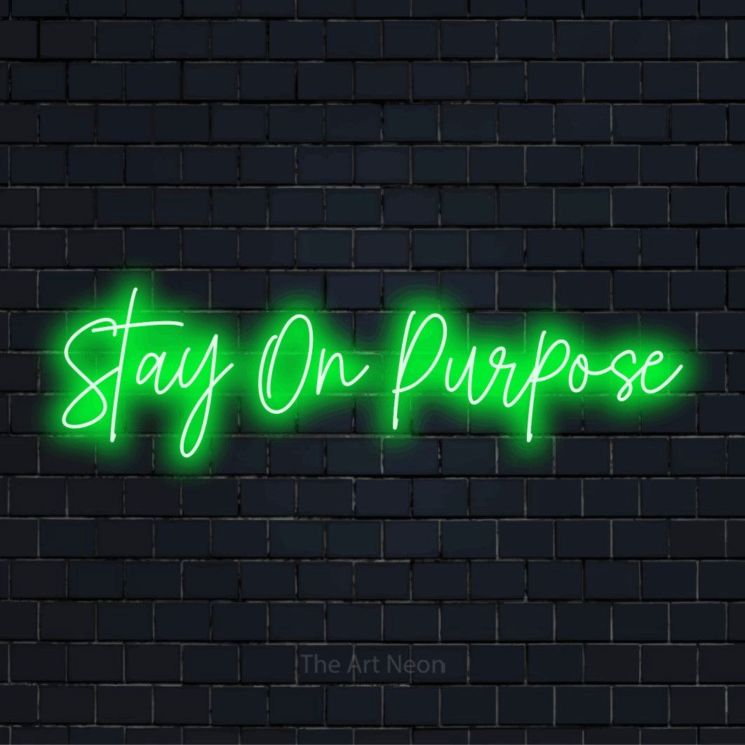 "Stay On Purpose" LED neon sign on a black brick wall