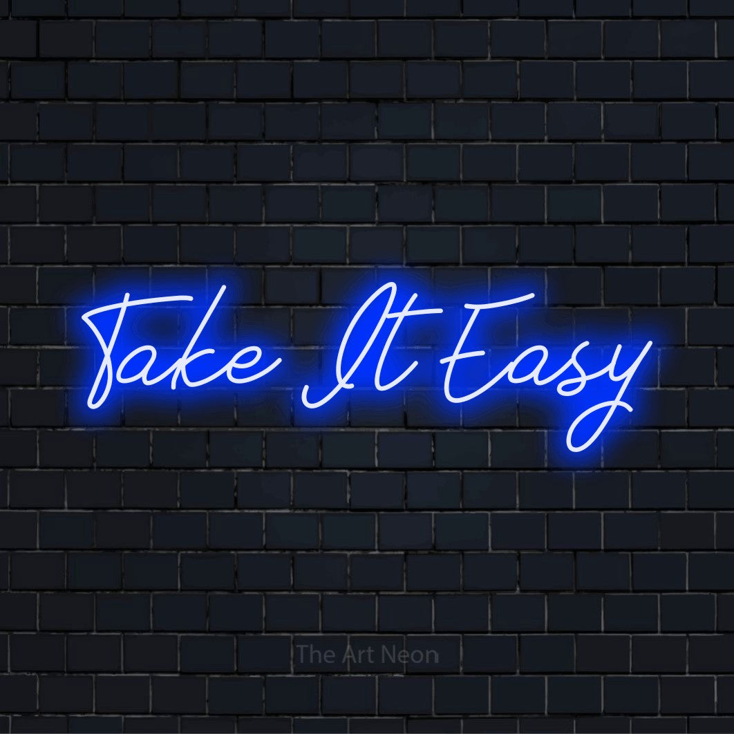 "Take It Easy" script-style LED neon sign on a black brick wall