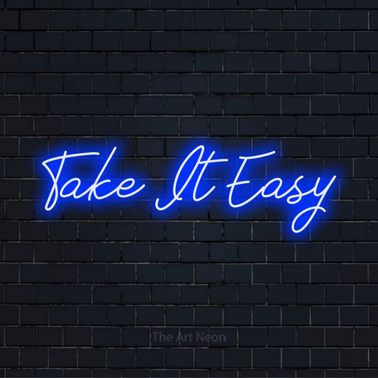 "Take It Easy" script-style LED neon sign on a black brick wall
