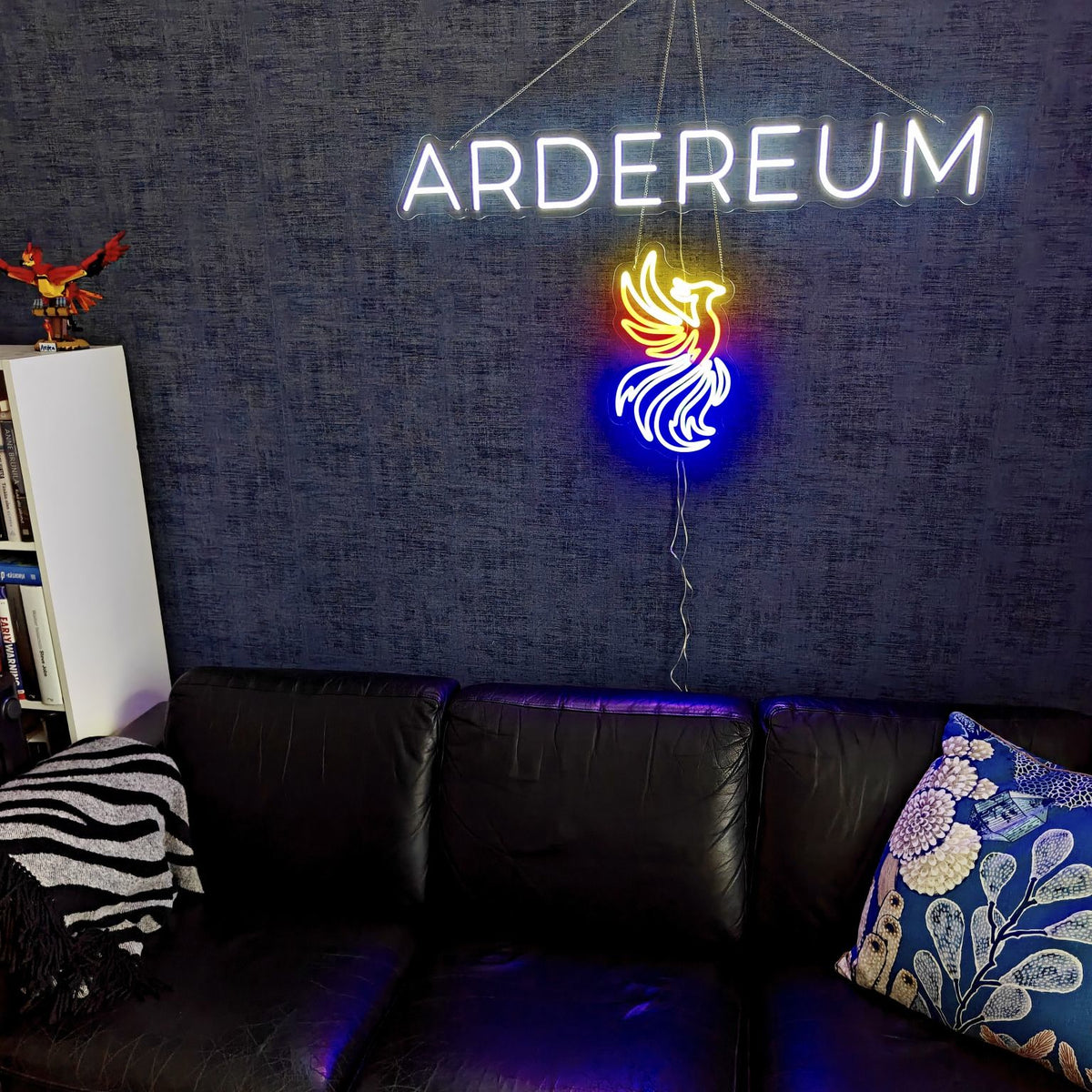 Vit ARDEREUM-logotyp i LED-neon på en mörk kontorsvägg med struktur.