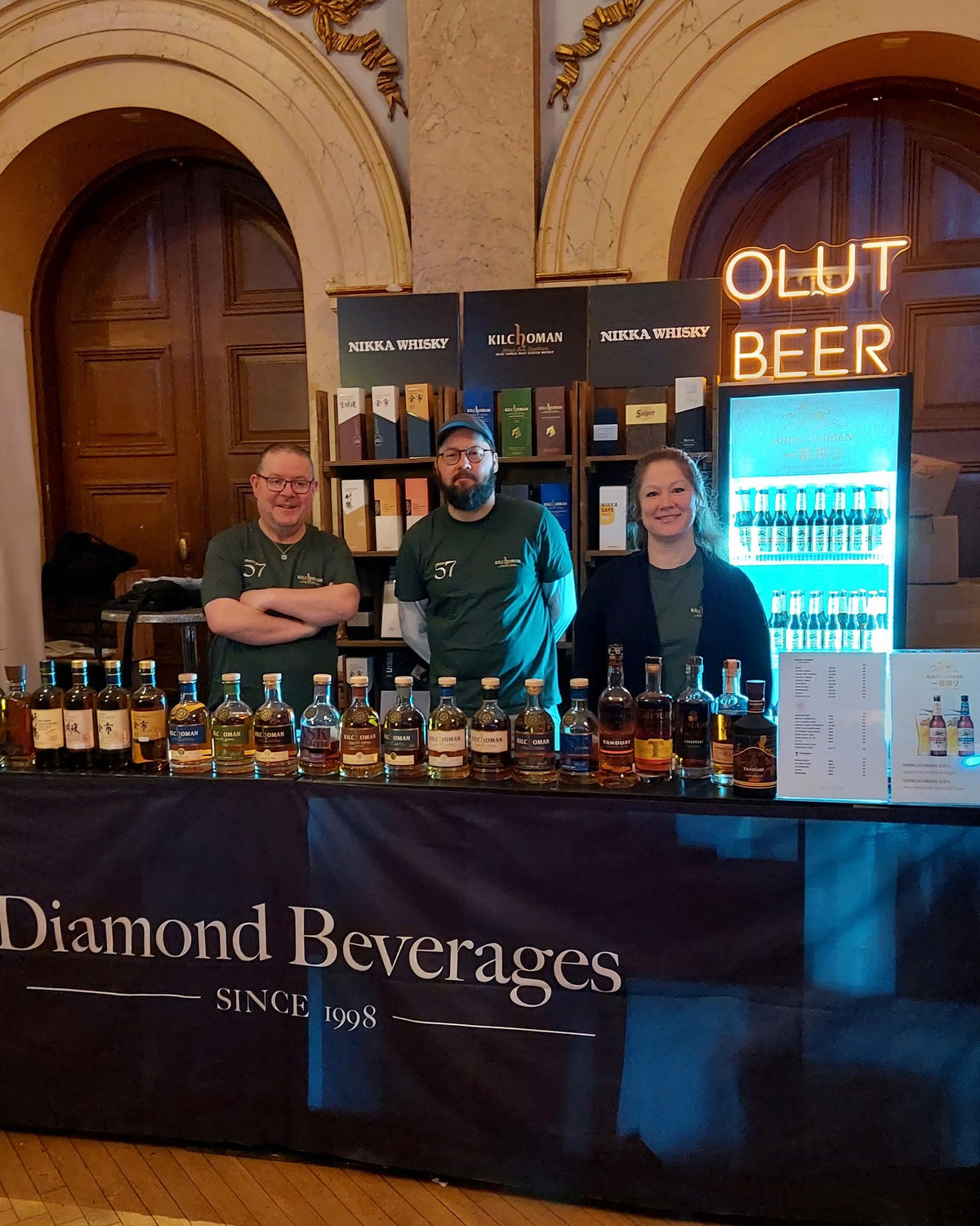 Varmt lysande OLUT BEER-text i LED-neon ovanför Diamond Beverages provsmakningsmonter.