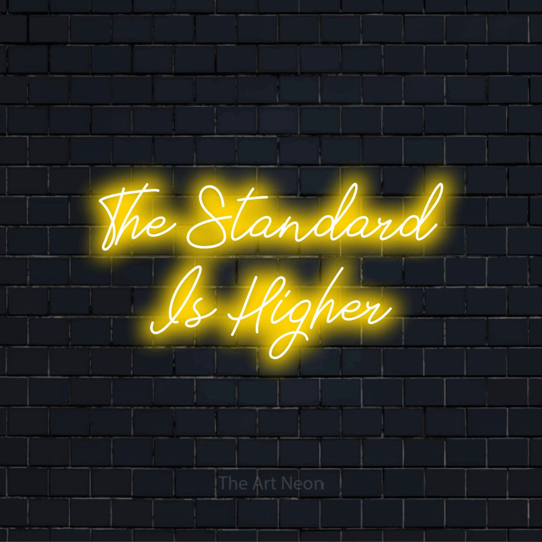 "The Standard Is Higher" glowing LED neon sign on a black brick wall