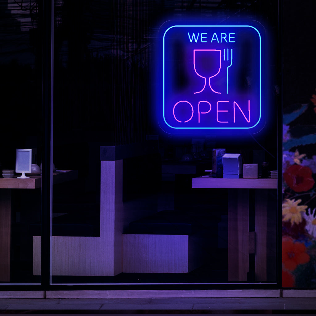 En fängslande neonskylt med symbolerna för en kopp och en gaffel, som indikerar att en restaurang eller matställe är öppen för affärer. 
