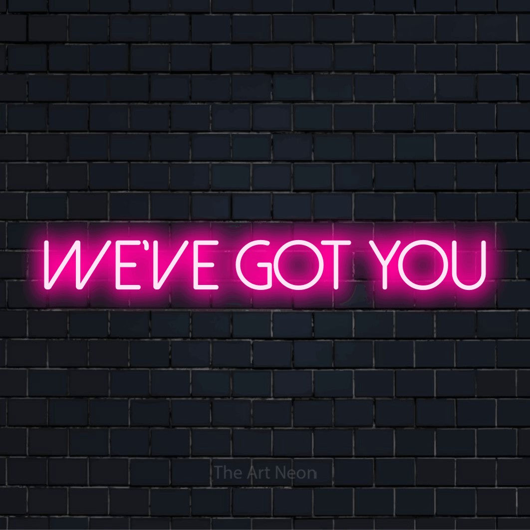 "We’ve Got You" glowing LED neon sign on a black brick wall