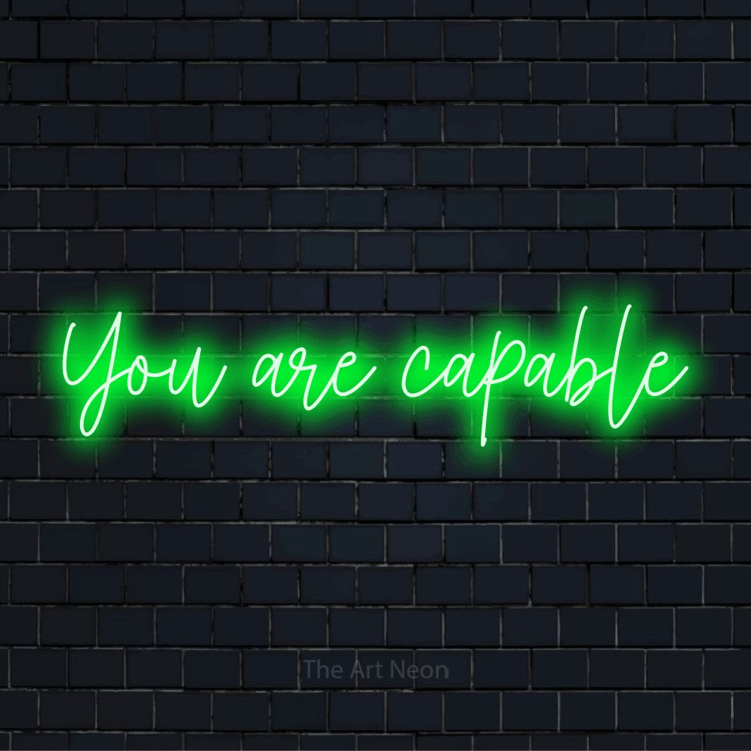 "You Are Capable" LED neon sign on a black brick wall