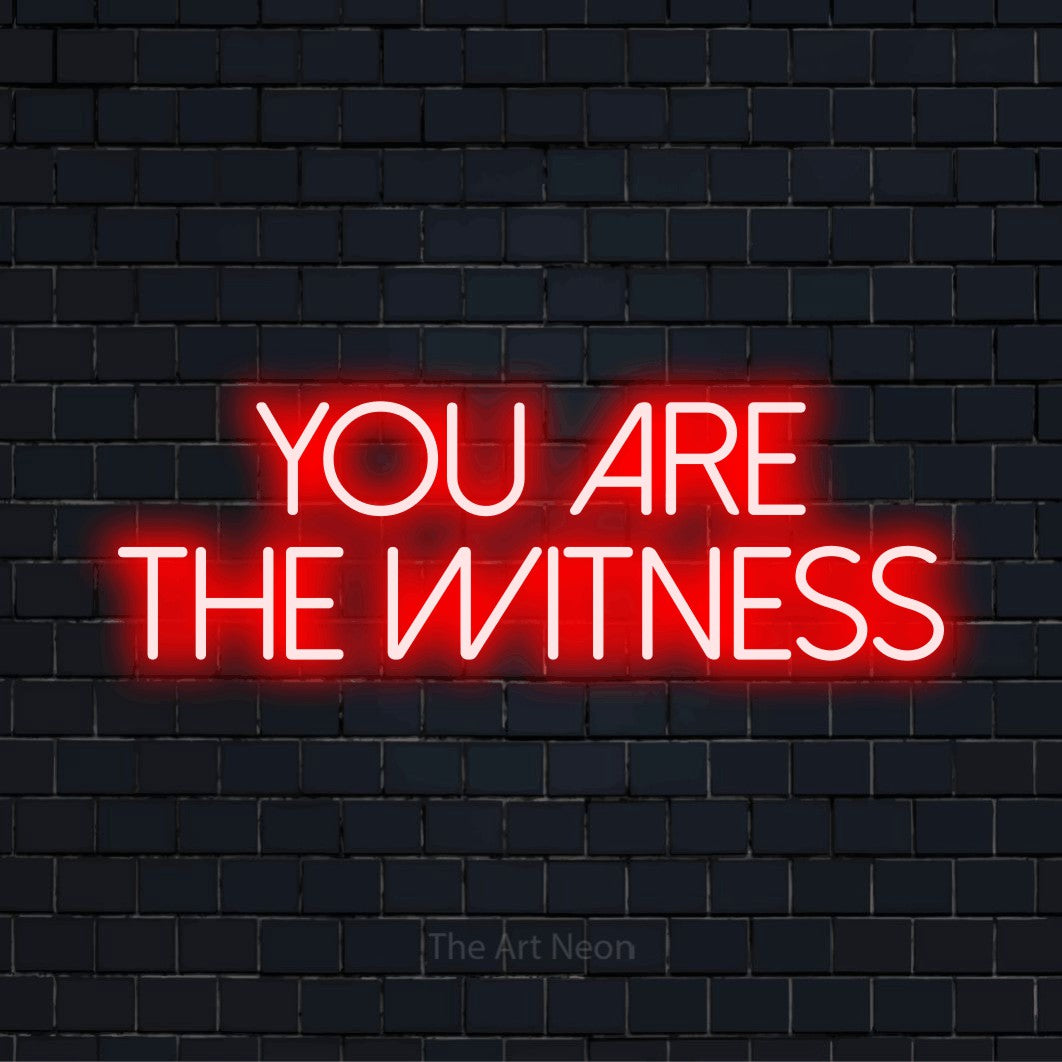 "You Are The Witness" text design with neon effect on a black brick wall