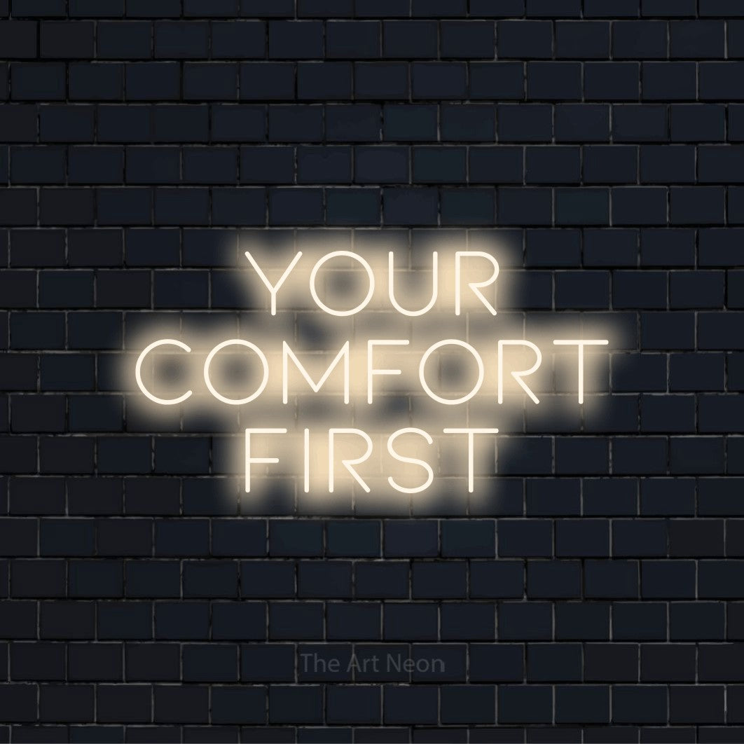 "Your Comfort First" LED neon sign on a black brick wall