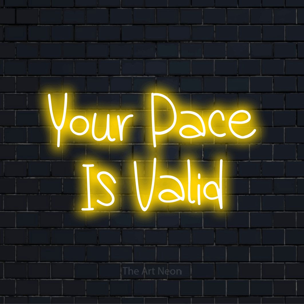 "Your Pace Is Valid" neon text design on a black brick wall